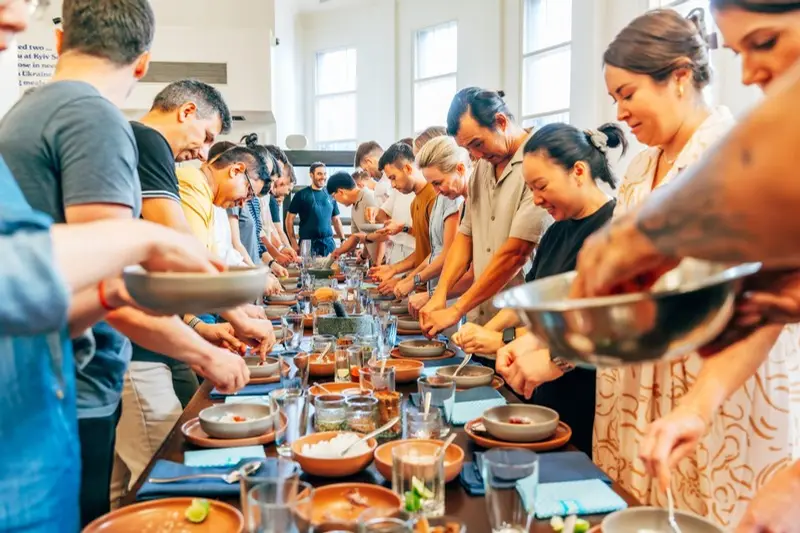 A team cooking side by side at a Plate Up Together Day