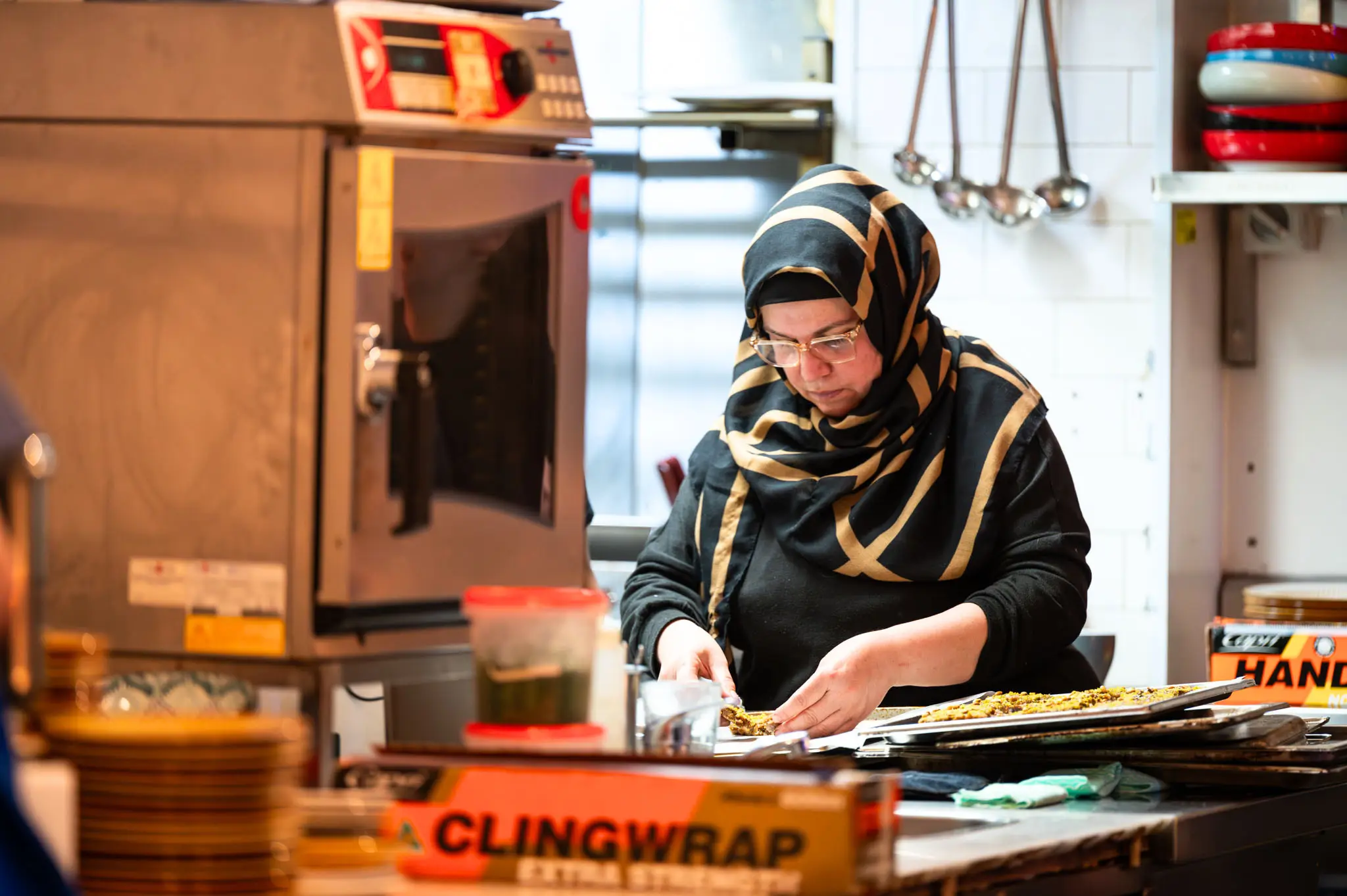 A Plate It Forward chef plating meals in the Alexandria kitchen