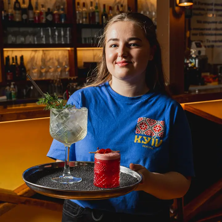 A Kyiv Social team member carrying drinks